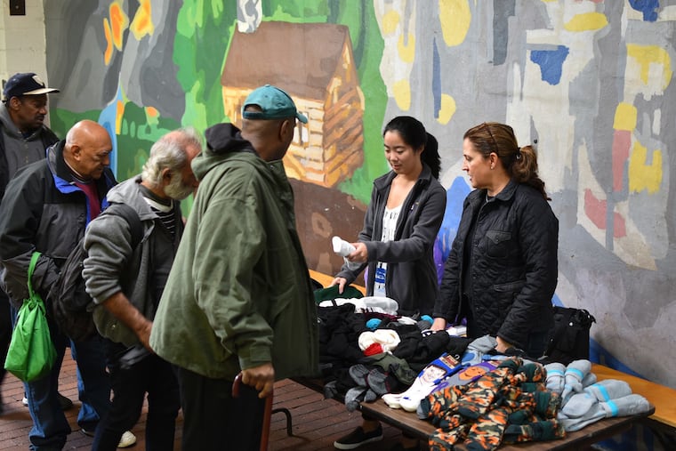 Volunteers for the nonprofit The Joy of Sox hand out new socks to those experiencing homelessness at St. John's Hospice in Philadelphia in 2018. (The Joy of Sox)
