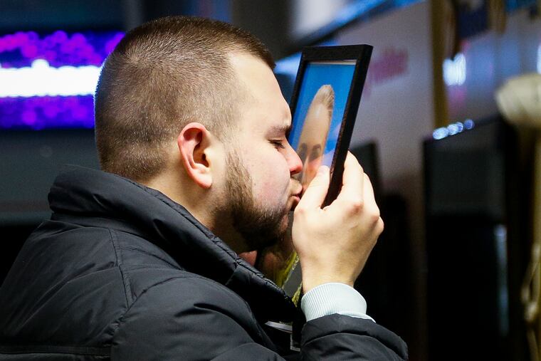 The partner of Julia Sologub, a member of the flight crew of the Ukrainian 737-800 plane that crashed on the outskirts of Tehran, kisses a portrait of her at a memorial inside Borispil international airport outside Kyiv, Ukraine.
