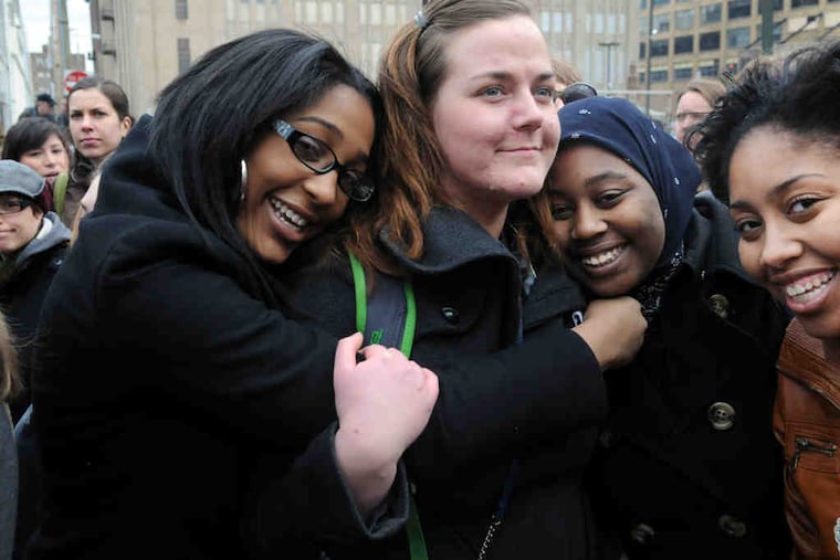 Teacher Hope Moffett is embraced by students Sydney Jackson (left), Jahneekqua Waiters (center), and Tyneesah Davenport.