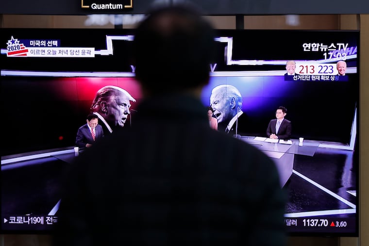 A man watches a TV screen showing the images of U.S. President Donald Trump and Democratic presidential candidate former Vice President Joe Biden during a news program of the U.S. presidential election, at the Seoul Railway Station in Seoul, South Korea, Wednesday, Nov. 4, 2020.