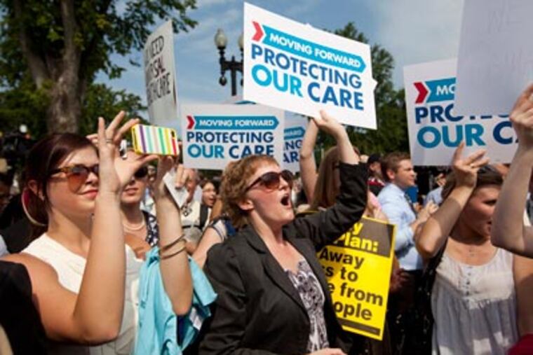 Demonstrators react to the Supreme Court landmark decision on health care, Thursday, June 28, 2012, outside the court in Washington. (AP Photo/Evan Vucci)