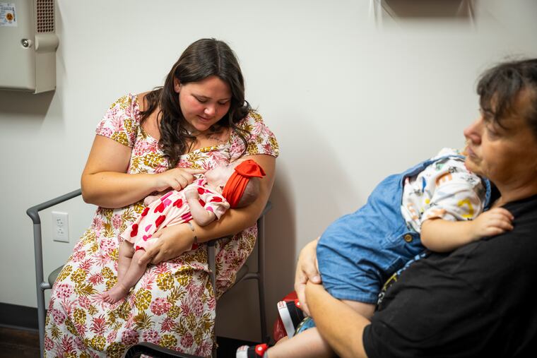 Jacalyn Stuff holds her daughter Roselynn before a routine ultrasound appointment at St. Claire Healthcare Medical Pavilion in Morehead, Ky. Jacalyn’s mother, Shannon Smith, holds Jacalyn’s son Xavier. MUST CREDIT: Arden S. Barnes/For The Washington Post