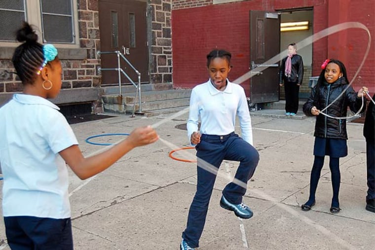 Makiyah Vincent, Tiffany McCormick, and Gianni Davis play jump rope.