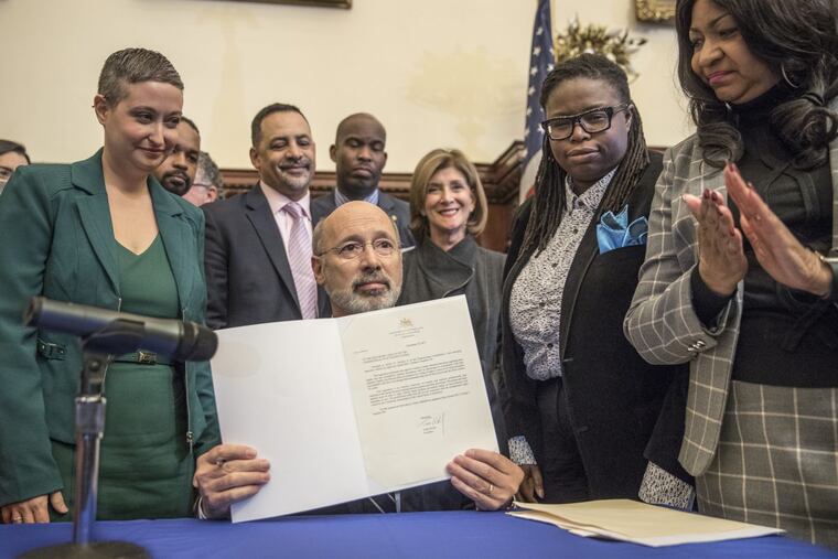 Surrounded by supporters, Pennsylvania Governor Tom Wolf holds up his signed veto of Senate Bill 3, legislation that would ban abortion after 20 weeks gestation.