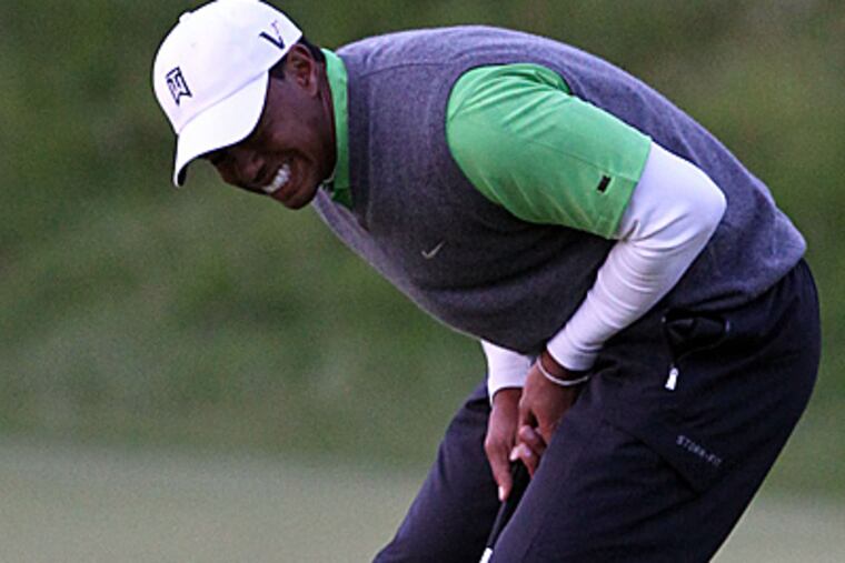 Tiger Woods reacts as he misses an eagle putt on the 18th green. (AP Photo/Peter Morrison)