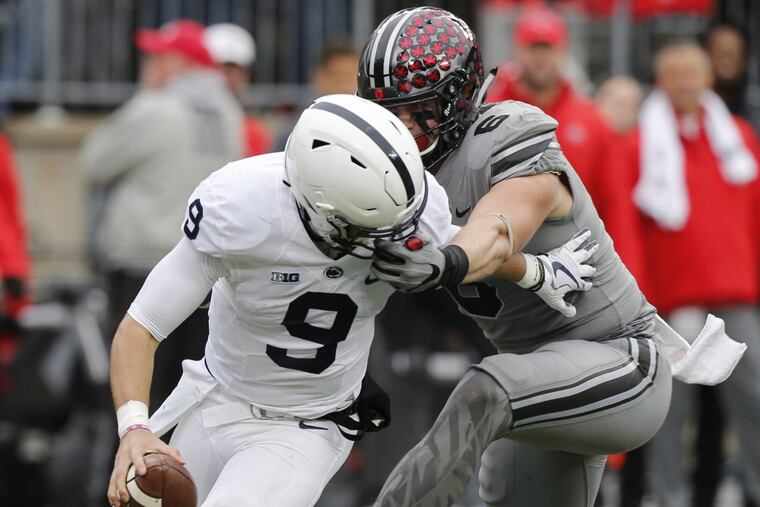 Ohio State defensive end Sam Hubbard, right, grabs the face mask of Penn State quarterback Trace McSorley during the first half of Penn State’s loss.