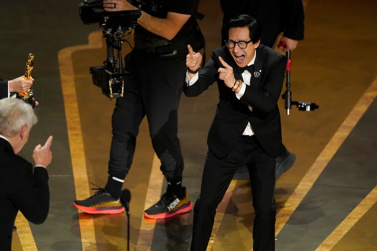 Harrison Ford, left, and Ke Huy Quan react onstage when "Everything Everywhere All at Once" wins the award for best picture at the Oscars on Sunday.