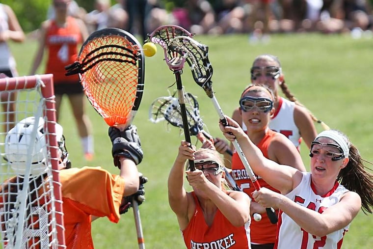 Cherry Hill East's Caitlin Delaney (12) shoots past Cherokee defender Lauren Thomas (11). Goalie Devon Kearns (left) made the save. DAVID M WARREN / Staff