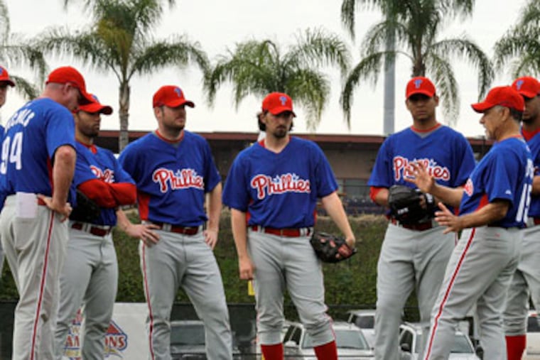Phillies pitchers listen to coach Davey Lopes, third from right, during a spring training baseball workout in Clearwater, Fla., Sunday. (AP Photo / Gene J. Puskar)