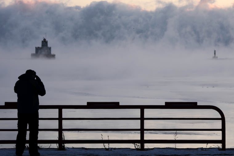Doug Kunde watches as steam is seen over Lake Michigan as temperature are not expected to reach zero degrees Friday in Milwaukee.
