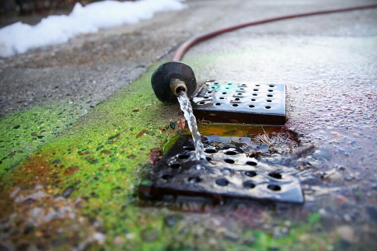 Philadelphia Water Department workers dye-test stormwater and sanitary sewer connections to investigate crossover issues, in which household sewage flows into the stormwater system and vice versa, on Ainslie Street in East Falls on Friday, March 16, 2018. Much of Philadelphia's sewage system combines household waste water and stormwater.