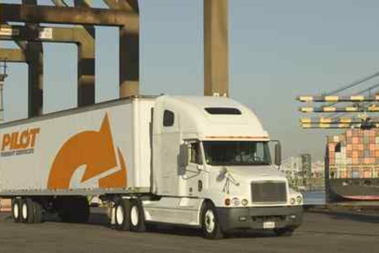 A truck from Pilot Freight Services picks up freight at a port. The firm's top executives are pictured below.