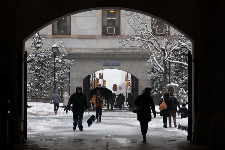 Pedestrians navigate snow and slush in the courtyard of City Hall, in Philadelphia, Wednesday, February 20, 2019.