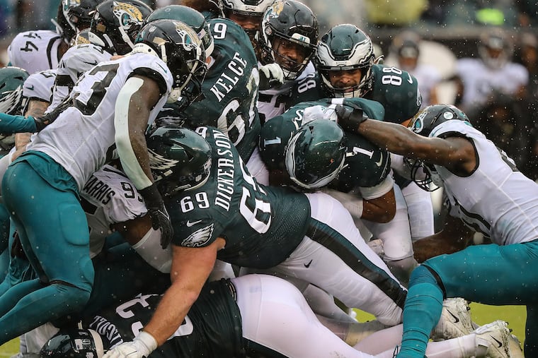 (From bottom to top) Philadelphia Eagles offensive tackle Jack Driscoll, Philadelphia Eagles center Landon Dickerson and Philadelphia Eagles center Jason Kelce push the Jaguars defensive line as Philadelphia Eagles quarterback Jalen Hurts (center) runs a quarterback sneak for the first down. Eagles play the Jacksonville Jaguars at Lincoln Financial Filed in Philadelphia, Pa. on Sunday, Oct. 2, 2022.