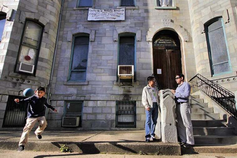 Gilberto Gonzalez (far right) and Miguel Ortiz (middle) talk while 8 yr old Lucas Teo Gonzalez (son of Gilberto) chases a handball in front of La Milagrosa Chapel, 1903 Spring Garden St. in Phila. on April 17, 2013. ( ELIZABETH ROBERTSON / Staff Photographer )