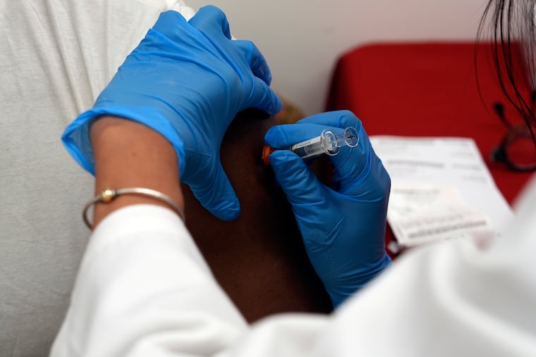 A pharmacist administers a COVID-19 vaccine at a pharmacy in New York.