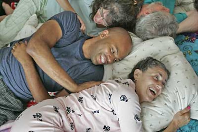 A cuddle party in full swing: Melvin Jones rubs the back of Linda Hunter, at bottom, while Denise Gilman rubs Jones' back. (Michael Bryant/Inquirer)