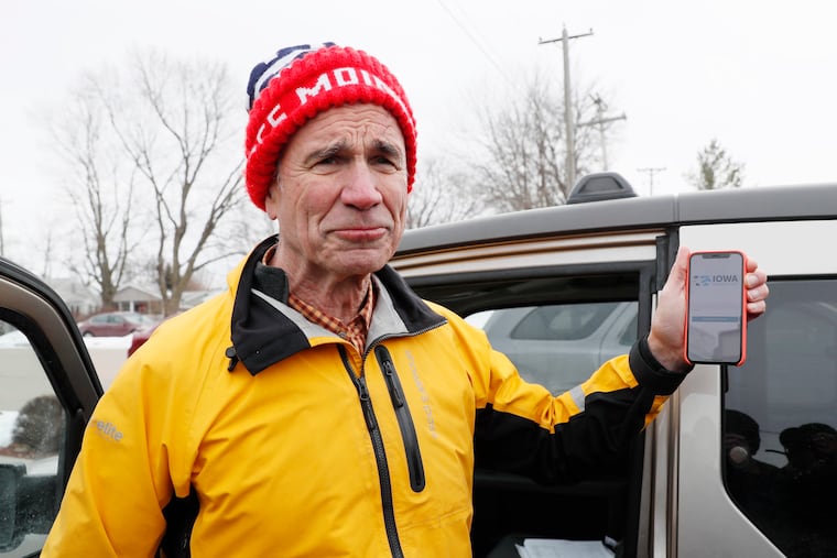 Precinct captain Carl Voss, of Des Moines, Iowa, holds his iPhone that shows the Iowa Democratic Party's caucus now much-maligned reporting app Tuesday, Feb. 4, 2020, in Des Moines, Iowa.