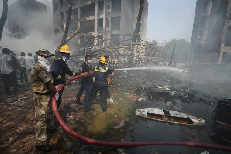 Firefighters work at the site of an airplane that crashed in India's northwestern city of Ahmedabad on Thursday, June 12, 2025.