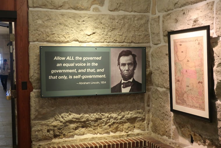 A historical exhibit at the Kansas Statehouse includes a display quoting President Abraham Lincoln next to a map showing the original extent of the Kansas-Nebraska territories before Kansas became a state and Lincoln took office in 1861.