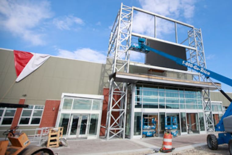 Exterior of XFINITY Live! DAVID SWANSON / Staff Photographer EDITORS NOTE: February 27, 2012, XFINITY Live! Philadelphia, 1100 Pattison Avenue, XFINITY28 Workers assemble and install 32-foot Sony High-Definition Television for XFINITY Live! Philadelphia as preparation continues for March 30th grand opening. This spectacular video display, the largest of its kind in any sports bar or restaurant in the Greater Philadelphia Region, is the crown jewel of the new sports bar and restaurant prominently featured among the many different dining and entetainment options currently under construction on the former site of the Spectrum. When completed, the $60 million XFINITY Live! Philadelphia will offer over a dozen different restaurant and entertainment options, including local Philadelphia favorites, an outdoor venue for live entertainment, and a unique sports viewing experience. Reporter Parmley will do text block caption. Workers assembled and installed a 32-foot Sony high-definition television on Monday (Feb 27) for Xfinity Live! The $60 million sports-themed entertainment and dining district on the site of the old Spectrum at the South Philadelphia stadium complex at 1100 Pattison Ave. debuts March 30. The project is a collaboration between Comcast-Spectacor — owner of the Flyers and Wells Fargo Center — and Baltimore-based Cordish Cos. The video display on the giant high-def TV is the centerpiece of a new sports bar and restaurant there that promises a unique live sports viewing experience. About a dozen other dining and entertainment options will be available at Xfinity Live!, including Chickie’s & Peter, Victory Brewing Co., and the Original Philadelphia Cheesesteak. The developers said they intend for the district to become a destination for sports and non-sports fans alike. It is opening a week ahead of originally planned<NO1>on April 5<NO> thanks in part to the mild winter. – Suzette ParmleyWorkers assembled and installed a 32-foot S