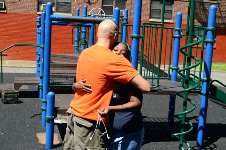 Adam Bruckner, who heads the children's ministry at the Helping Hand Rescue Mission, greets Tedra DeVaux, 20, while playing with kids in the neighborhood August 14, 2013. She is one of just a handful of children in the neighborhood to go onto college. He once battled back stereotypes he'd held throughout his life about the poor, and now sees himself as an advocate of poor kids currently locked in a never-ending feud between two housing projects, Richard Allen and Spring Garden. (TOM GRALISH / Staff Photographer)