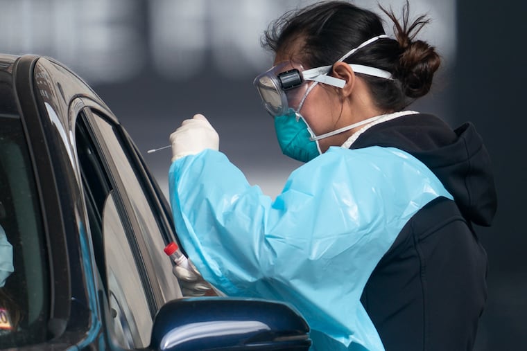 A medical staff person works at the testing site located at 10th and Sansom Streets, in Philadelphia, April 3, 2020.