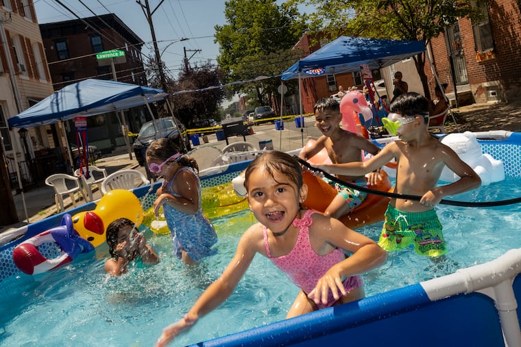 Children play in an above-ground pool at a block party in the Ludlow section of Philadelphia on Saturday.