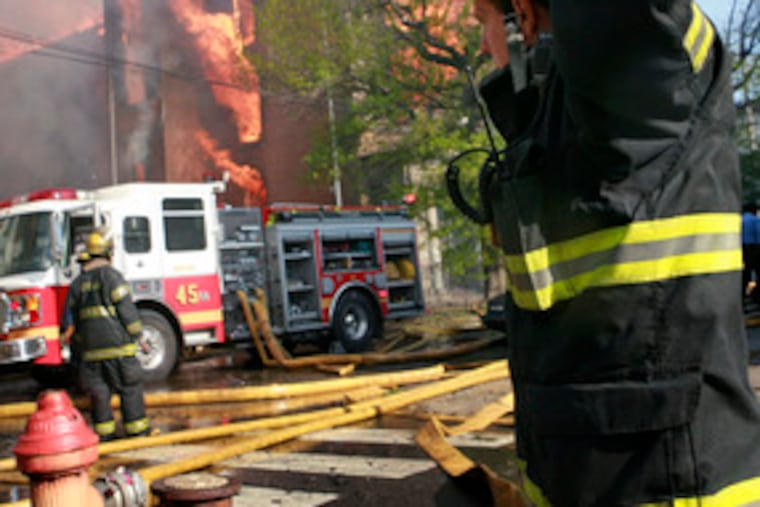 Firefighters battle the six-alarm blaze at 32nd and Berks that produced clouds of smoke that could be seen for miles.