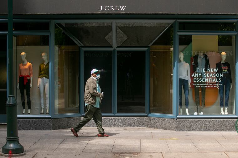 A man walks past a closed store in Center City. The path to re-opening has brought anxieties about how to navigate the new normal.