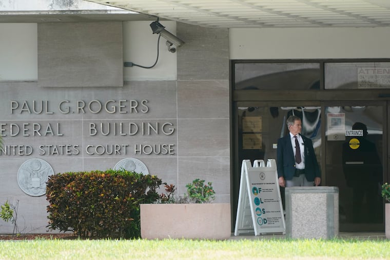 A security guard stands outside the Paul G. Rogers Federal Building and U.S. Courthouse in September in West Palm Beach, Fla.