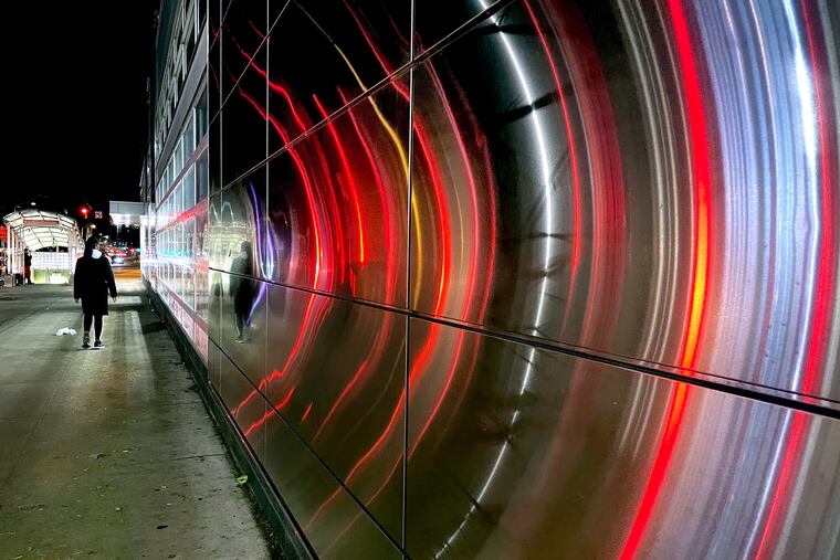 Reflections of traffic on the (flat) metal facade of a business near SEPTA’s Spring Garden subway station on the Broad Street Line.
