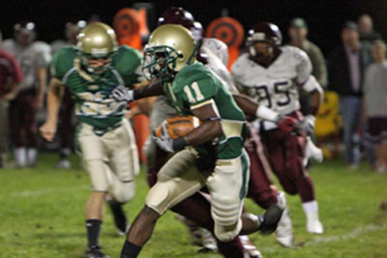 Camden Catholic's Jerry Watters sprints past Holy Cross defenders. The Irish, beaten by an aggregate 74-14 the last three years by the Lancers, snapped that skid with a 27-0 victory. (Kevin Cook / Staff Photographer)