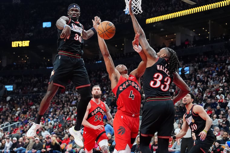 Toronto Raptors' Scottie Barnes (4) is fouled on his way to the hoop by Jabari Walker (33) as Sixers' Adem Bona (30) looks on during first half on Sunday.