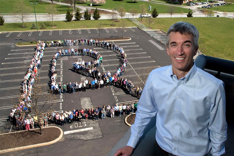 Radial employees form the company's new logo - a stylized "R" - as chief executive Tobias Hartmann looks on. The retail-logistics company employs 700 people at its newly consolidated headquarters in King of Prussia.
