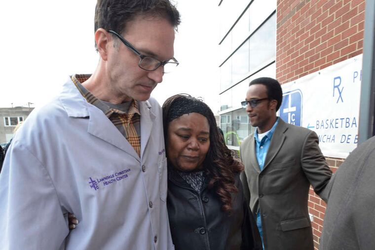 Mourners walk into a Cure International office in Chicago where Umanos worked. The nonprofit began work in 1996.