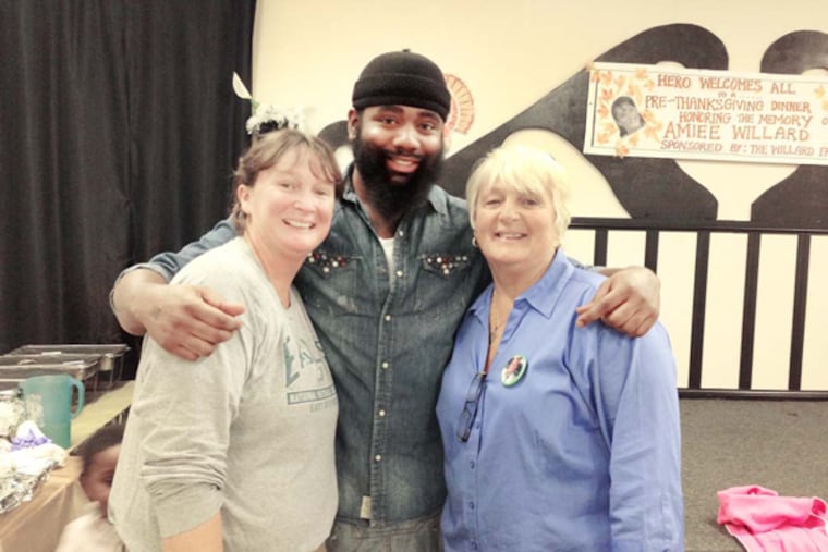 Aimee Willard’s sister Nancy and mother Gail pose with Jason Culler during a holiday meal at the Hero Community Center on North 17th Street. (Helen Ubinas / Daily News)