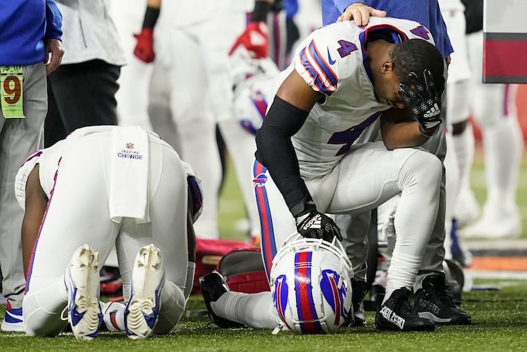 Buffalo Bills players and staff pray for Buffalo Bills' Damar Hamlin during the first half of an NFL football game against the Cincinnati Bengals, Monday, Jan. 2, 2023, in Cincinnati.