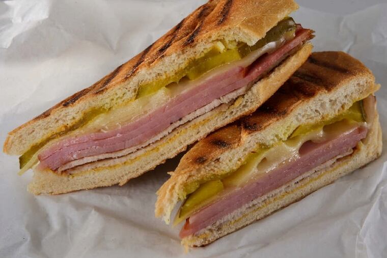 A traditional Cuban sandwich recipe calls for sliced ham, roast pork with a citrusy marinade (called mojo) and Swiss cheese layered in a loaf of Cuban bread. The sandwich is then garnished with pickles and mustard. (Zbigniew Bzdak/Chicago Tribune/MCT)