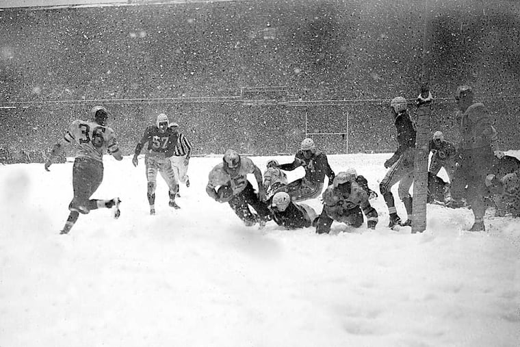 Steve Van Buren (15) of the Philadelphia Eagles plunges over the goal line with a fourth period touchdown that defeated the Chicago Cardinals in the driving snowstorm in Philadelphia, Pa., Dec. 1948. Other players are, Bill Blackburn (57) and John Cochrane (24) of the Cardinals. (AP Photo)