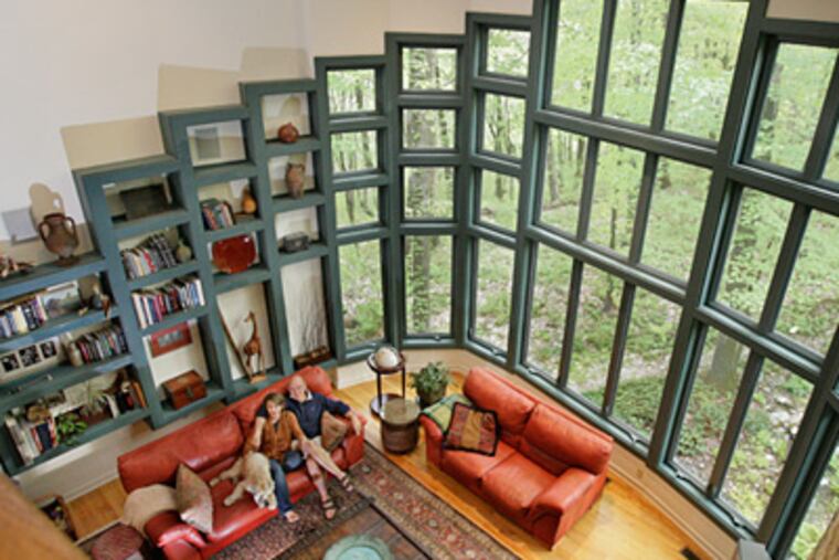 Jill and Michael Zimmner and their dog, Say D, in their great room which features a window grid that transitions into shelves. ( Elizabeth Robertson / Staff Photographer )