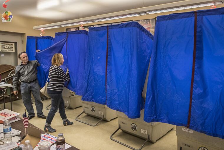 John Powell, left, the Judge of Elections for Ward 26, 4th Division, lifts the blue covering for a voter to enter the voting machine in the polling place at the bocci court at Marconi Plaza on Tuesday May 16, 2017. Voter turnout was low, around 30 as of noon. Polling place at Marcello Tenaglia Bocci Court in South Philadelphia at Marconi Plaza. Voters are heading to the polls today for Pennsylvania's primary election. 05/16/2017 MICHAEL BRYANT / Staff Photographer