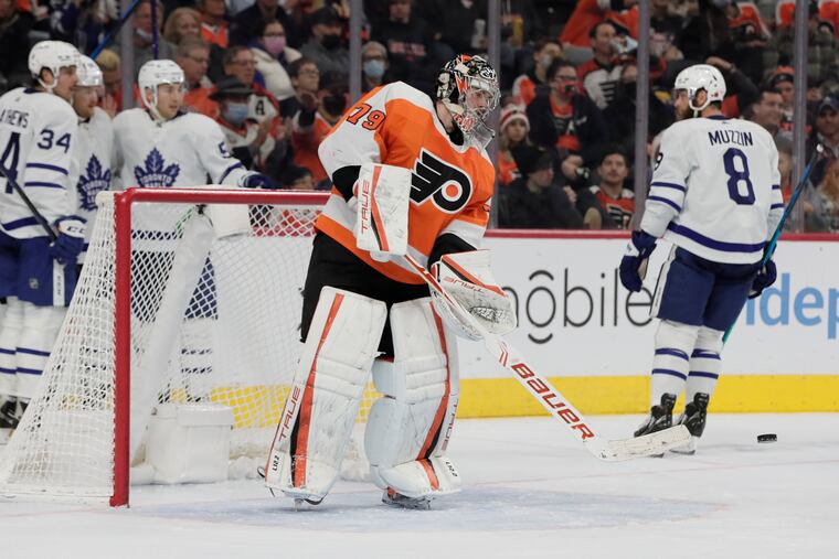 Flyers goalie Carter Hart smacks the puck away after Toronto's first goal in the second period .