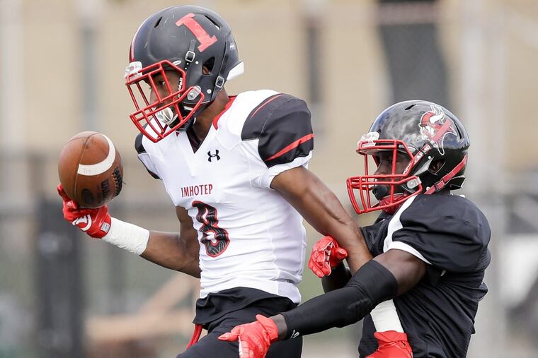 Imhotep High’s Yusuf Terry (left) battles for a pass against Northeast High’s Alex Martin during the first quarter of Imhotep’s win.