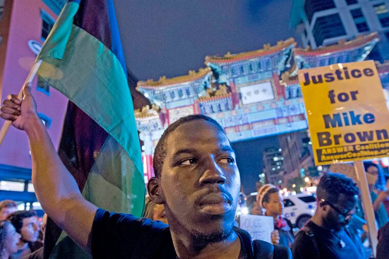 Demonstrators march through the streets in the Chinatown neighborhood of Washington, Saturday, Aug. 23, 2014, during a protest against the shooting of unarmed Michael Brown, a black 18-year-old killed by a white police officer in Ferguson, Mo. (AP Photo/Jose Luis Magana)