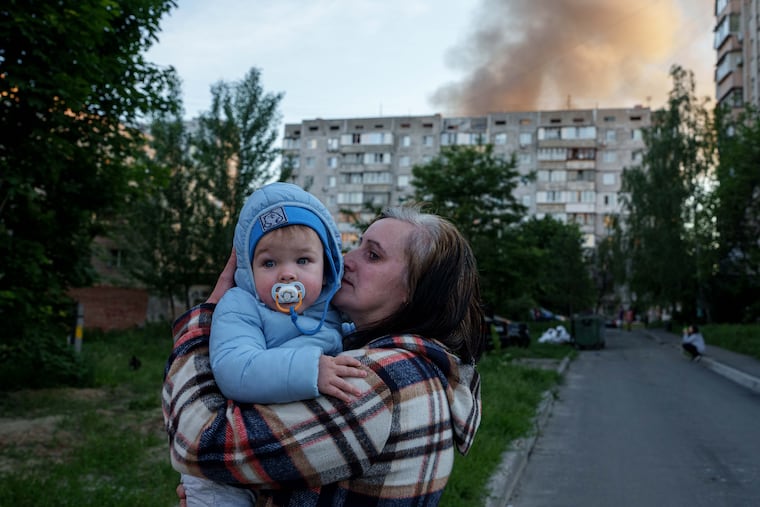 A woman carries a baby near a residential house damaged after a Russian strike in Kyiv, Ukraine, on Tuesday, June 2, 2026.