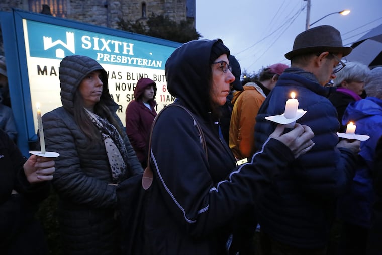 A crowd holds candles on the lawn of the Sixth Presbyterian Church at the intersection of Murray Ave. and Forbes Ave. in the Squirrel Hill section of Pittsburgh during a memorial vigil for the victims of the shooting at the Tree of Life Synagogue where a shooter opened fire on Saturday.