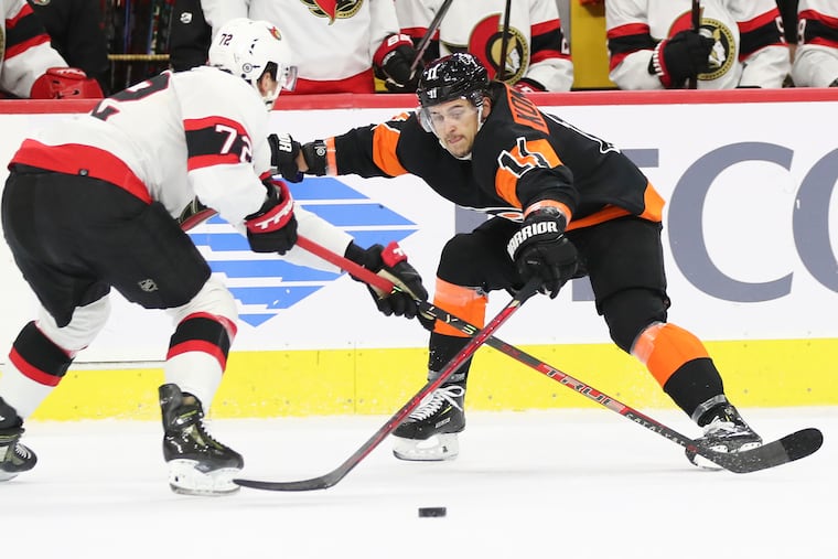 Flyers right wing Travis Konecny reaches for the puck against Ottawa Senators defenseman Thomas Chabot on Dec. 18.