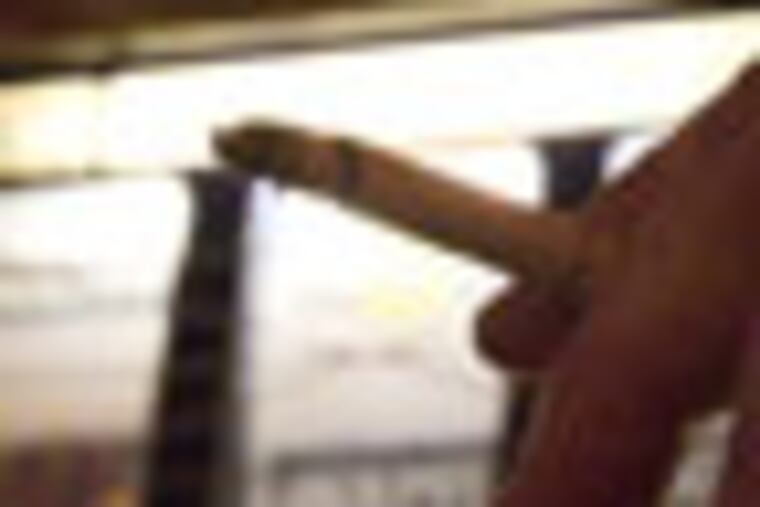 (hand with cigarette) Dave Stout, 64, of Barnegat, plays a slot machines and smokes in what will soon be a designated no smoking are on the gaming floor at the Borgata Casino, Atlantic City (David M Warren/Inquirer) EDITORS NOTE: CASINO11Pd 92419 ATLANTIC CITY 4/10/07 Atlantic City casinos are making final preparations for the smoking ban that takes effect this Sunday, 4/15. The casinos will be permitted to retain 25% of the gaming floor as designated smoking areas. Photos taken at the Borgata Casino on 4/10. 3/