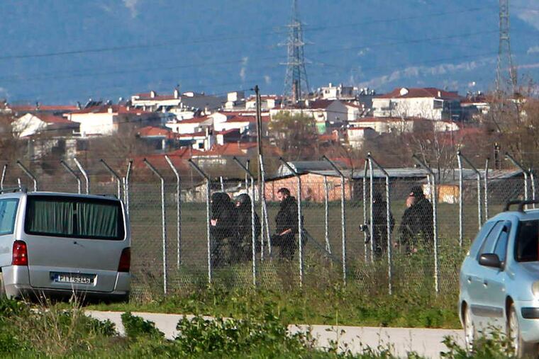 Police officers patrol near the prison outside Trikala in central Greece where gunmen attacked with grenades and automatic weapons Friday.